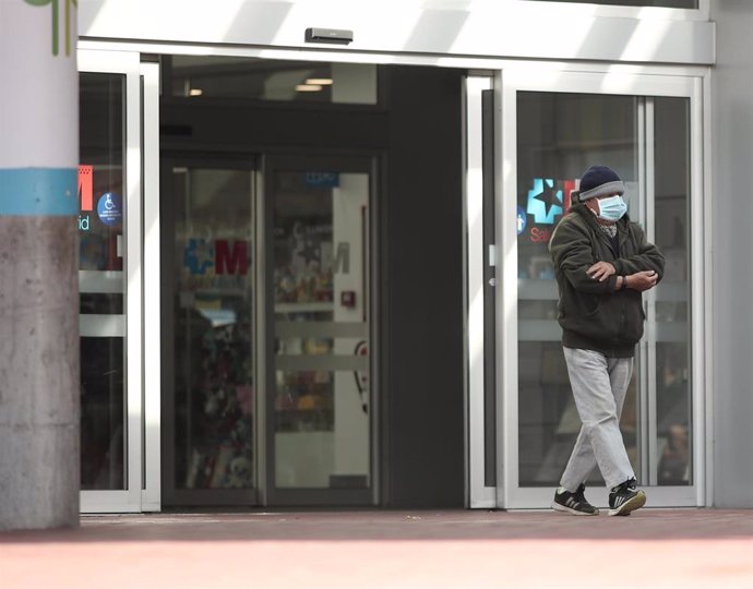Un hombre con mascarilla camina por las zonas exteriores del Hospital de Torrejón donde se encuentran hospitalizados varios pacientes por dar positivo en coronavirus. Actualmente, se estudia el motivo por el que Torrejón es uno de los focos más grandes 