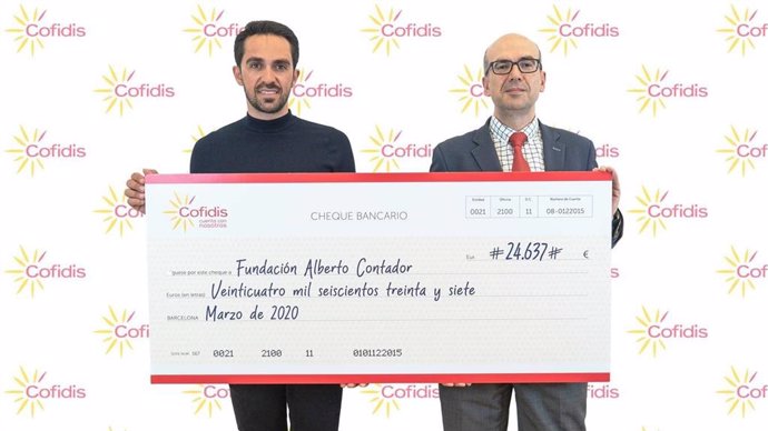Alberto Contador junto a Manuel Fernández con el cheque de la donación