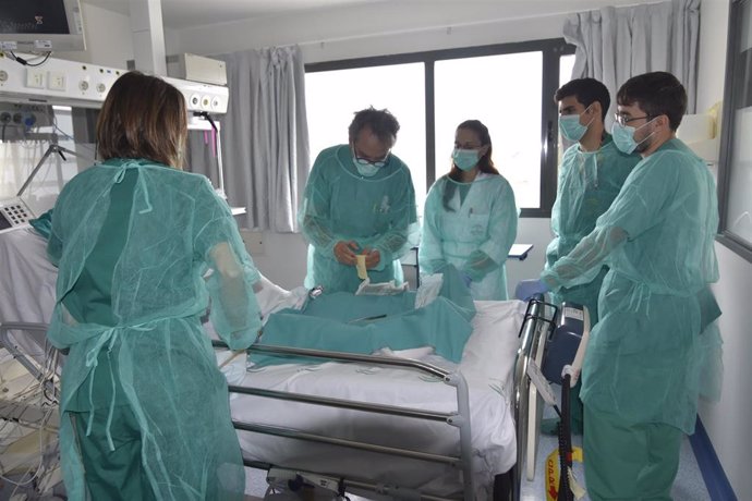 Lorenzo Pérez practica una cura a un paciente en la Unidad de Cuidados Intensivos