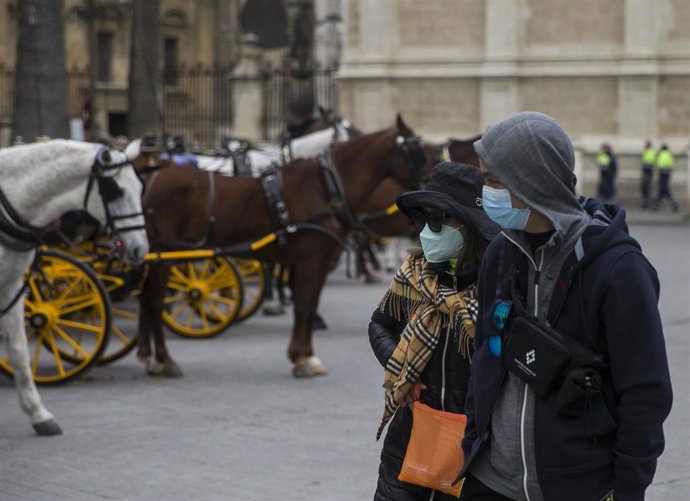 Imágenes del impacto del virus del Coronavirus en el sector turístico . Dos turistas con mascarillas pasean por el centro de Sevilla (Andalucía, España), a 03 de marzo de 2020.
