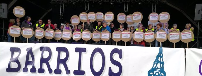 Representantes de los barrios de Zaragoza sostienen carteles con sus reivindiaciones.