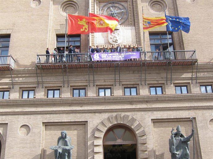 El alcalde de Zaragoza, Jorge Azcón, coloca una pancarta en el balcón del Ayuntamiento con motivo del 8 de marzo, junto con los grupos de PSOE, PP, Ciudadanos y Zaragoza en Común (ZeC).