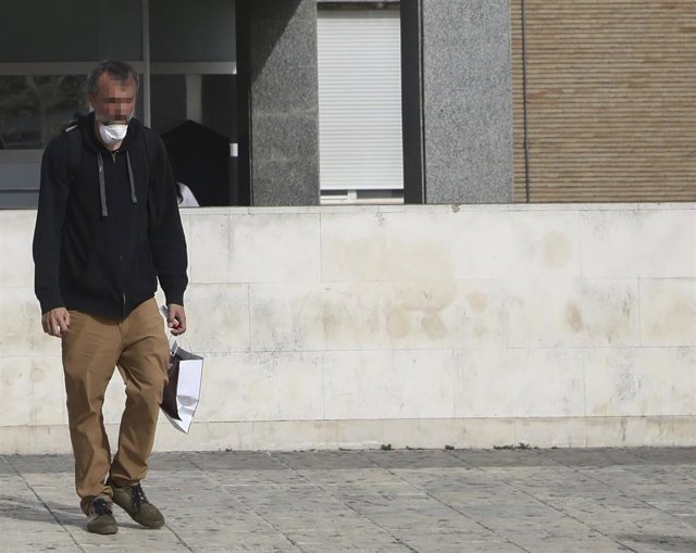 Un hombre con la mascarilla sin colocar sale del Hospital Universitario Virgen del Rocío