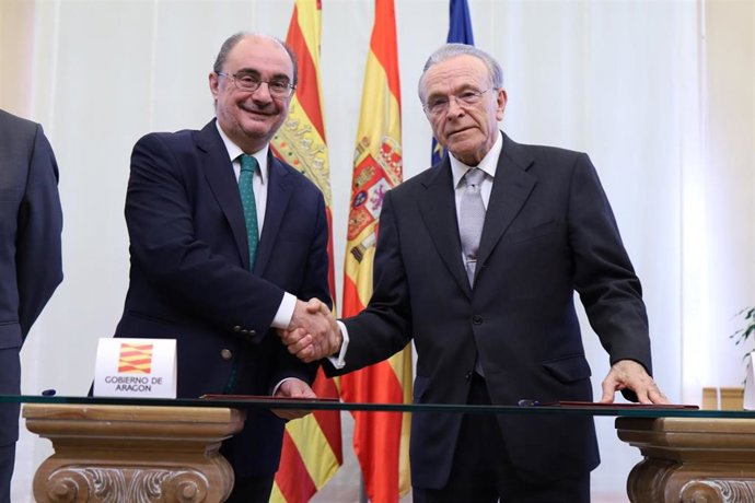 El presidente del Gobierno de Aragón, Francisco Javier Lambán (i), y el presidente de la Fundación Bancaria 'la Caixa', Isidro Fainé (d), se estrechan la mano durante la firma del acuerdo.