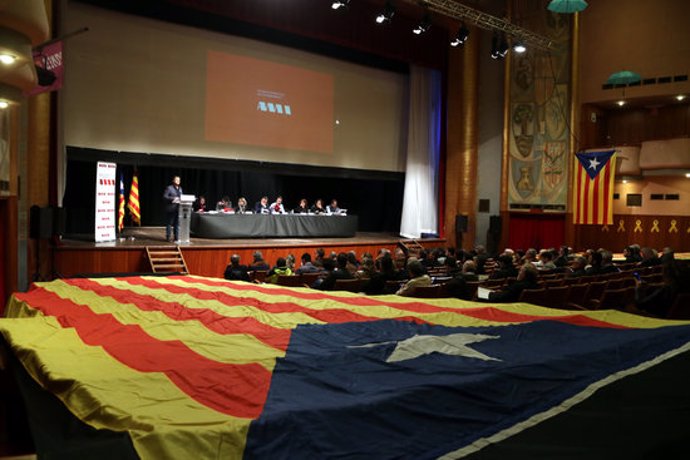 Pla general del Casal de l'Espluga de Francolí durant l'assemblea general de l'AMI, amb una estelada gegant en primer terme. Imatge del 6 de mar del 2020. (Horitzontal)