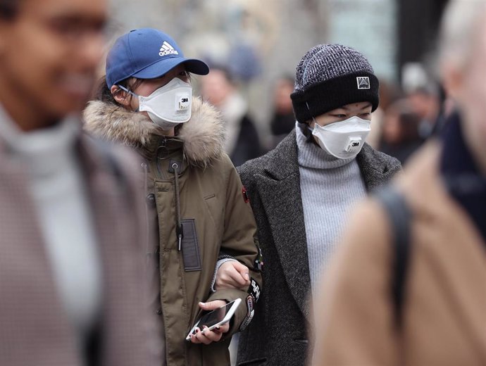 Imagen de varias personas con mascarillas en Londres.