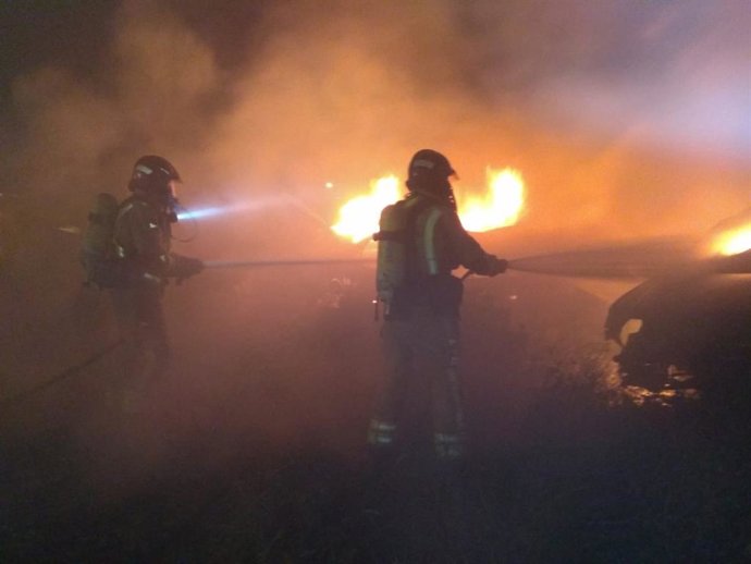 Bomberos trabajan en las labores de extinción de un incendio en un desguace