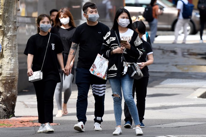 09 March 2020, Australia, Sydney: People wear face masks as they walk on street as precaution of the spread of the COVID-19 (coronavirus). Photo: Bianca De Marchi/AAP/dpa