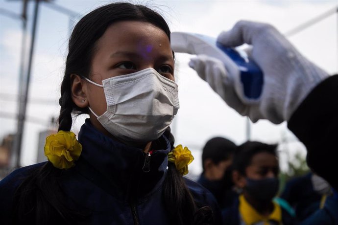 Una niña de Nepal se somete a un control de temperatura por el coronavirus
