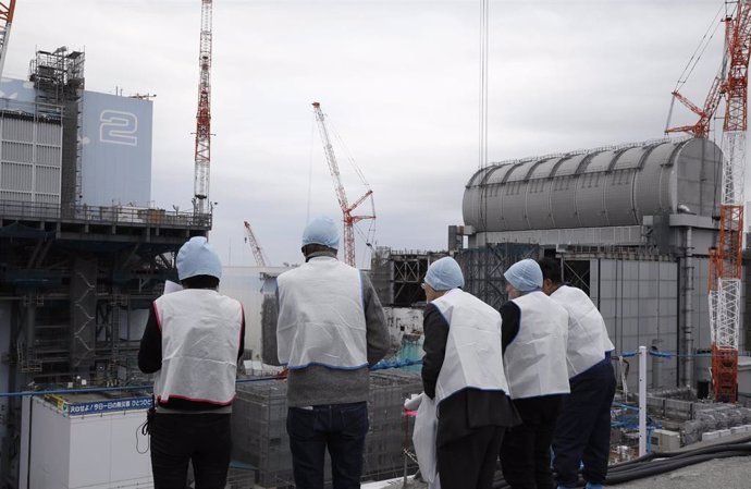 22 January 2020, Japan, Okuma: Journalists inspect Unit 2 (L) and Unit 3 (R) reactor houses during their inspection tour at tsunami-devastated Tokyo Electric Power Company (TEPCO) Fukushima Daiichi Nuclear Power Plant. Photo: Kimimasa Mayama/POOL/dpa