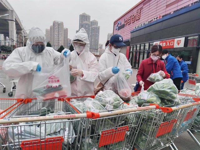 Voluntarios y trabajadores de Wuhan preparan bolsas de vegetales para residentes