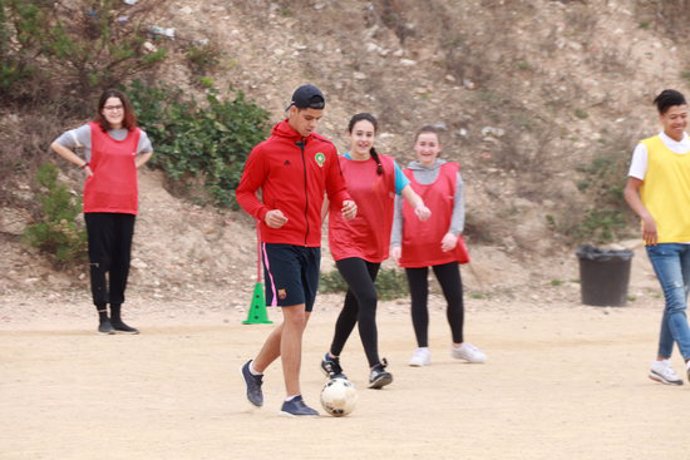 Pla general dels joves que participen en el programa Spectrum - United By Diversity jugant a futbol al pati de l'institut Martí i Franqus de Tarragona. Foto del 10 de mar del 2020 (Horitzontal).