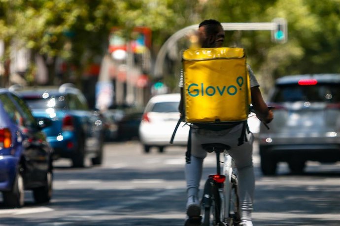 Un 'rider' de la compañía de comida a domicilio, Glovo, circula con su bicicleta por una calle de Madrid.