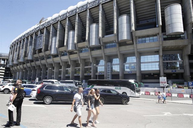 Algunas personas caminan por los alrededores del Estadio Santiago Bernabéu de Madrid.