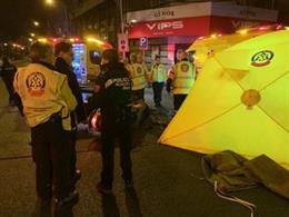 Sanitarios del Samur-Protección Civil atienden a un motorista atropellado en la calle Alcalá de Madrid