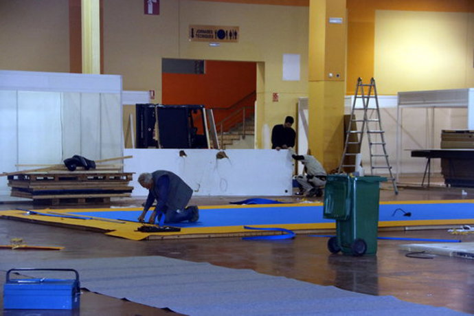 Pla obert on es poden veure operaris treballant en el muntatge dels estands als Pavellons Firals per a la 148a Fira de Sant Josep a Mollerussa, l'11 de mar de 2020. (Horitzontal)