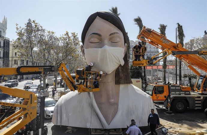 Operarios ponen una mascarilla a la Falla del Ayuntamiento un día después de la suspensión de las Fallas por el Gobierno de la Generalitat de Valencia, en Valencia (Comunidad Valenciana, España), a 11 de marzo de 2020.