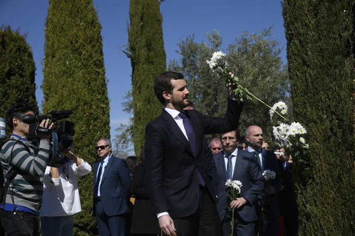 El presidente del PP, Pablo Casado, coloca un ramo de flores blancas entre los cipreses del Bosque del Recuerdo, tras el acto de homenaje a las víctimas del atentado terrorista del 11-M en el Parque del Retiro, en Madrid (España) a 11 de marzo de 2020.