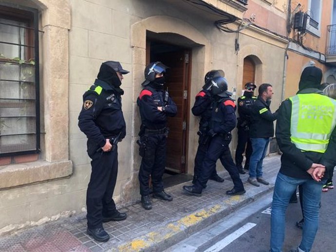 Diversos efectius policials de la Gurdia Urbana de Barcelona i els Mossos d'Esquadra durant una actuació contra el trfic de drogues a l'Eixample l'11 de mar del 2020. Pla general. (Horitzontal)