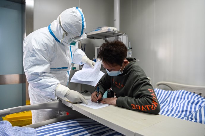 12 February 2020, China, Lhasa: A man (R), who recovered after being infected by a new coronavirus, ends checkout procedures after discharging from hospital upon recovery in Lhasa. Photo: -/TPG via ZUMA Press/dpa