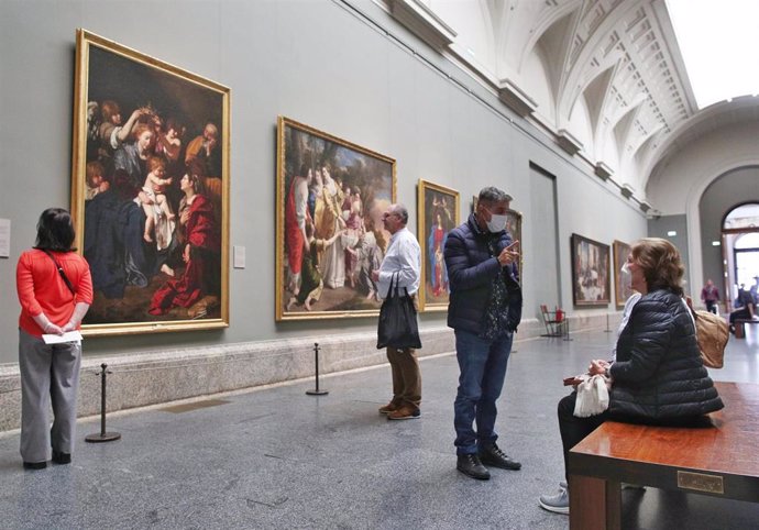 Dos personas con mascarillas en la Galería Central del Museo Nacional del Prado el mismo día en el que el Museo, junto con el Reina Sofía y el Thyssen, cierra como medida de contención frente a la crisis del coronavirus, en Madrid (España) a 11 de marzo