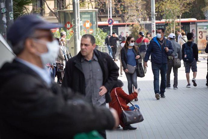 Dos personas caminan en zonas cercanas a la Sagrada Familia protegidos con mascarillas ante el avance del coronavirus en Barcelona