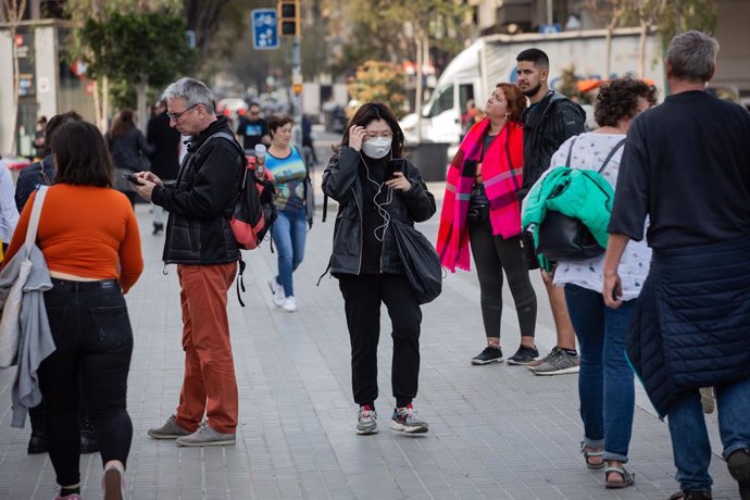Una jove camina per zones properes a la Sagrada Família protegida amb mascarilla davant l'avan del coronavirus a Barcelona