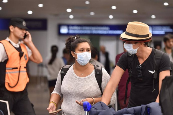 Personas con mascarillas en el aeropuerto de Buenos Aires.