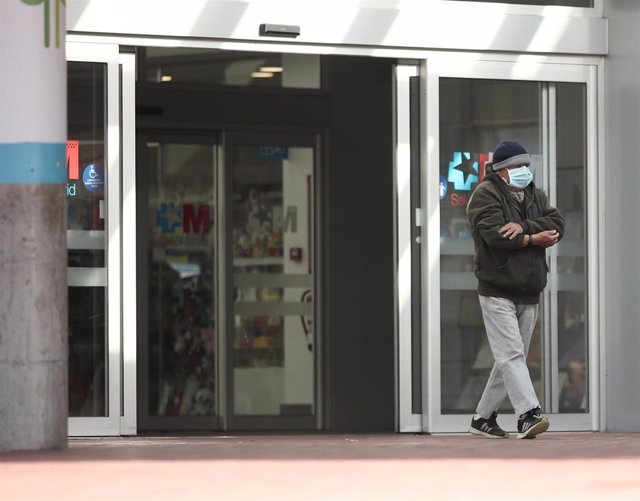 Un hombre con mascarilla camina por las zonas exteriores del Hospital de Torrejón 