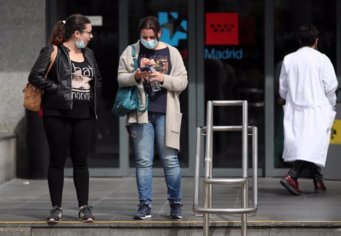 Dos mujeres protegidas con mascarilla a las afueras del Hospital de la Paz