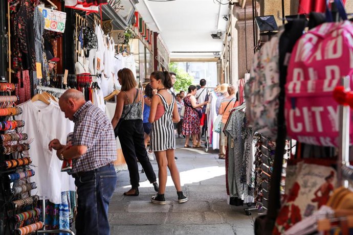 Varios turistas realizan compras en una de las tiendas ubicada en una calle cercana a la Plaza Mayor de Madrid.