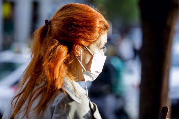 Una mujer pasea por el centro de Madrid con mascarilla como medida de protección frente al Coronavirus 