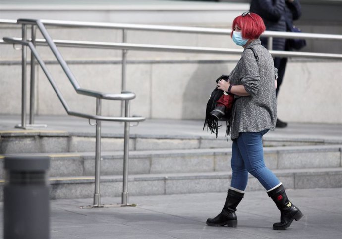Una mujer protegida con mascarilla a las afueras del Hospital de la Paz donde se ha habilitado un espacio para atender "en mejores condiciones" a pacientes sospechosos de coronavirus, en Madrid (España), a 12 de marzo de 2020.
