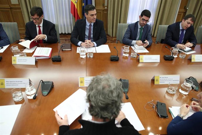 El ministro de Sanidad, Salvador Illa (1i), habla con el presidente del Gobierno, Pedro Sánchez (2i), acompañados del director del Centro de Coordinación de Alertas y Emergencias Sanitarias del Ministerio de Sanidad, Fernando Simón (frente a Sánchez), d