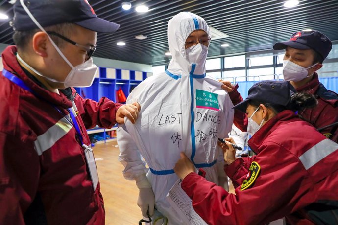 Treballadors mdics a Wuhan escriuen el missatge "últim ball" en el vestit de la seva companya després de confirmar el tancament dels 16 hospitals temporals oberts pel brot del coronavirus.