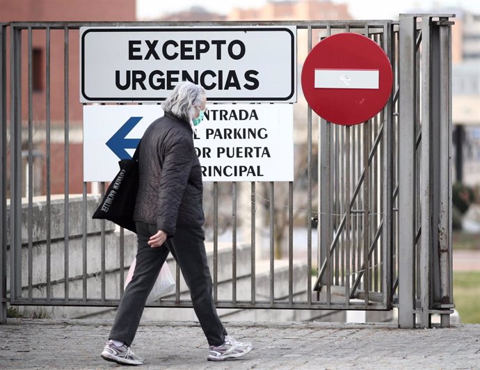 Una mujer protegida con mascarilla pasea cerca de la puerta de Urgencias del Hospital Universitario Fundación Alcorcón