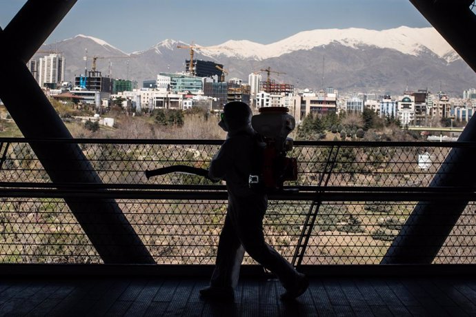 Un treballador sanitari desinfecta un pont a l'Iran.