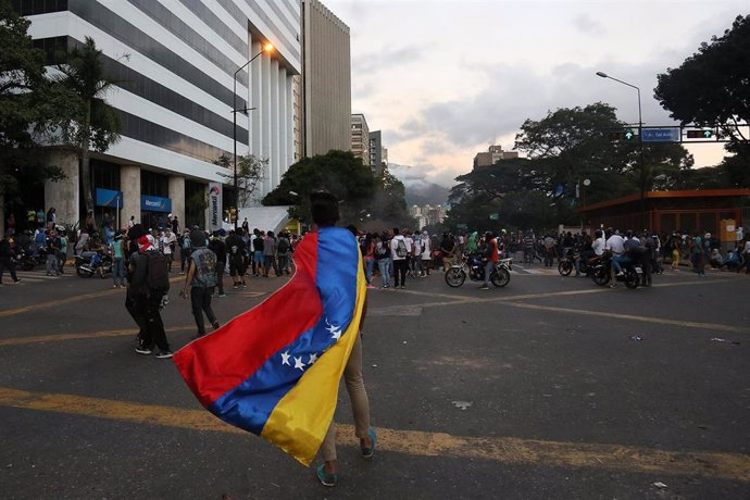 Manifestante con la bandera de Venezuela en Caracas