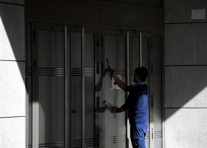 Un trabajador limpia los cristales de la Audiencia Nacional de Madrid, en Madrid (España), a 11 de marzo de 2020.