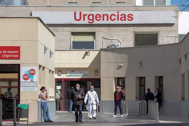 Varias personas protegidas con mascarilla se encuentran cerca de la puerta de Urgencias del Hospital Gregorio Marañón, un día después de que el presidente del Gobierno, Pedro Sánchez, declarase el Estado de Alarma debido a la crisis del coronavirus en Esp