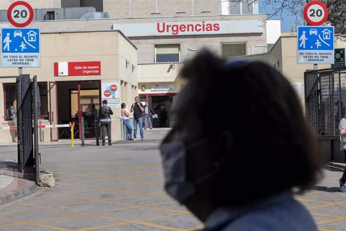 Una mujer protegida con mascarilla pasea cerca de la puerta de Urgencias del Hospital Gregorio Marañón, un día después de que el presidente del Gobierno, Pedro Sánchez, declarase el Estado de Alarma debido a la crisis del coronavirus en España, en Madri