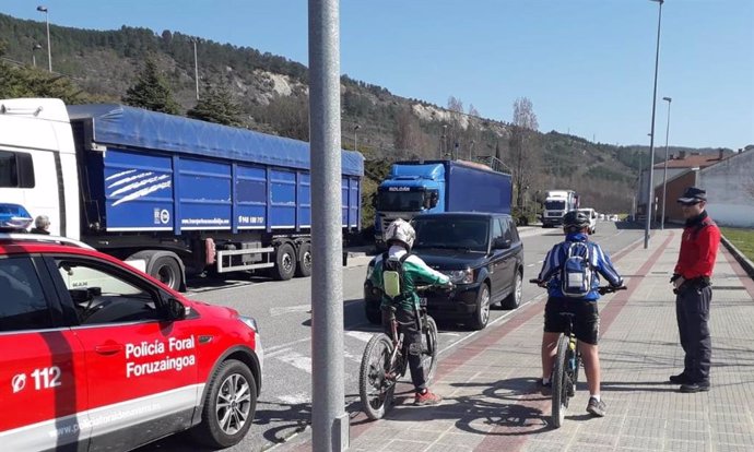 Un agente de la Policía Foral informa a dos ciclistas de las restricciones por el estado de alarma