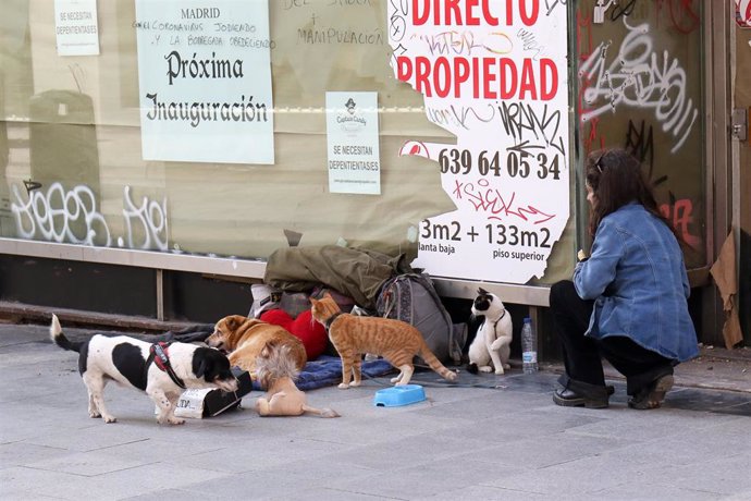Una mujer observa a una personas sin hogar en la calle de Madrid durante la crisis del coronavirus a 15 de marzo de 2020.