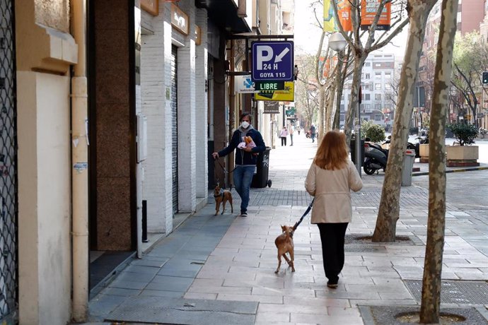 Una mujer pasea con su perro por una calle de Madrid durante la crisis del coronavirus en Madrid a 15 de marzo de 2020.