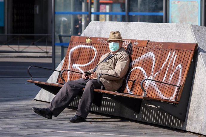 Un hombre con mascarilla sentado en un banco en Madrid durante la crisis del coronavirus en Madrid a 15 de marzo de 2020.