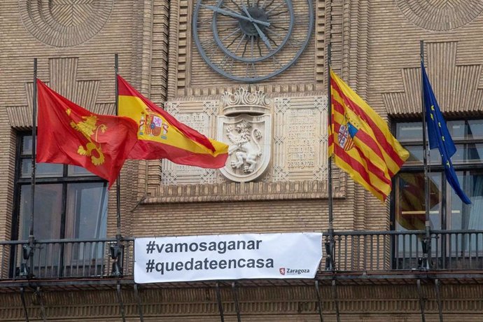 Una pancarta con el lema "#vamosaganar" "#quedateencasa'  para animar a combartir el coronavirus cuelga  del balcón del Ayuntamiento de Zaragoza
