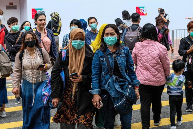 Transeuntes ataviados con mascarillas cruzan una calle de Hong Kong.