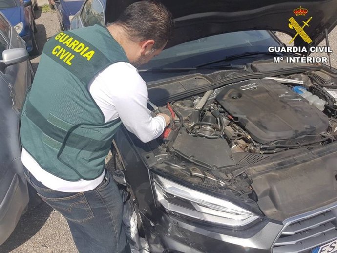 Un agente inspecciona el coche localizado.
