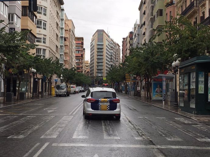 Un coche patrulla en uan vacía avenida Méndez Núñez de Alicante.