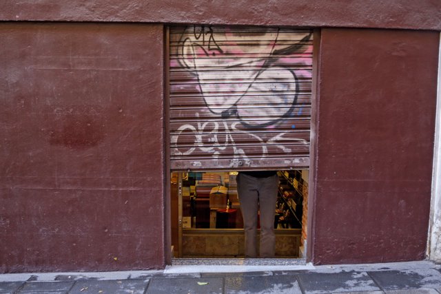 Un autónomo echa el cierre de su negocio tras su jornada laboral. En Madrid (España), a 24 de febrero de 2020.